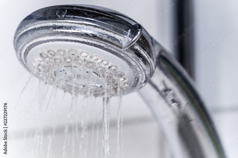 Verkalkter Duschkopf mit ungleichmäßigem Wasserfluss – Regendusche entkalken